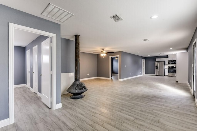 unfurnished living room with ceiling fan and light hardwood / wood-style flooring