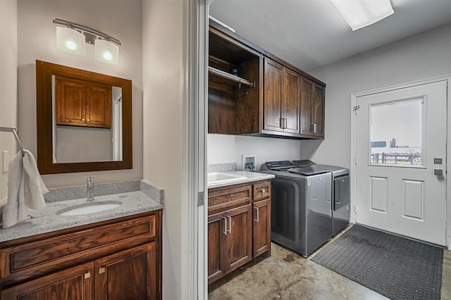 clothes washing area with cabinets, sink, and washing machine and clothes dryer