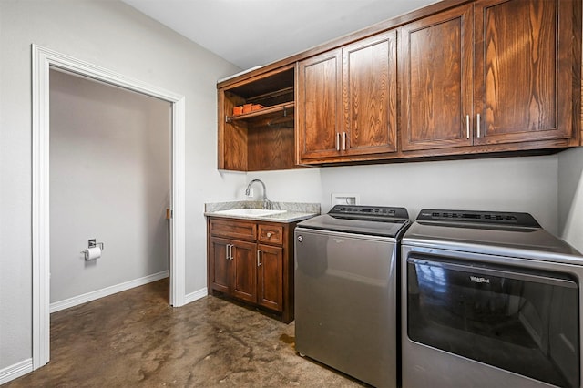 laundry area featuring cabinets, separate washer and dryer, and sink