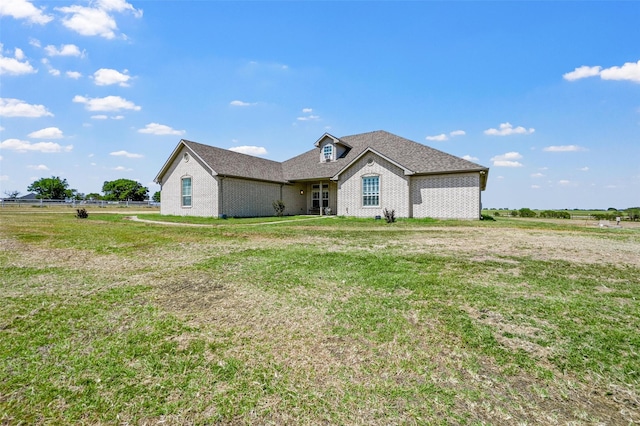 view of front of house with a rural view and a front lawn