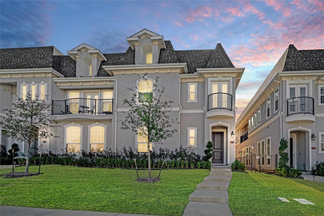 french country style house with a yard and a balcony