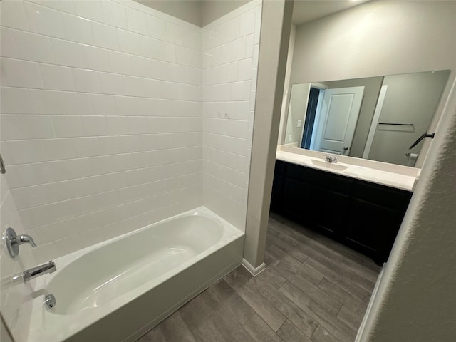 bathroom with bathing tub / shower combination, hardwood / wood-style floors, and vanity