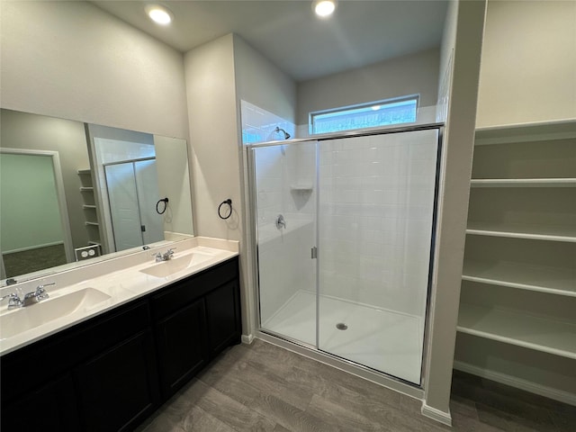 bathroom featuring wood-type flooring, vanity, and a shower with shower door