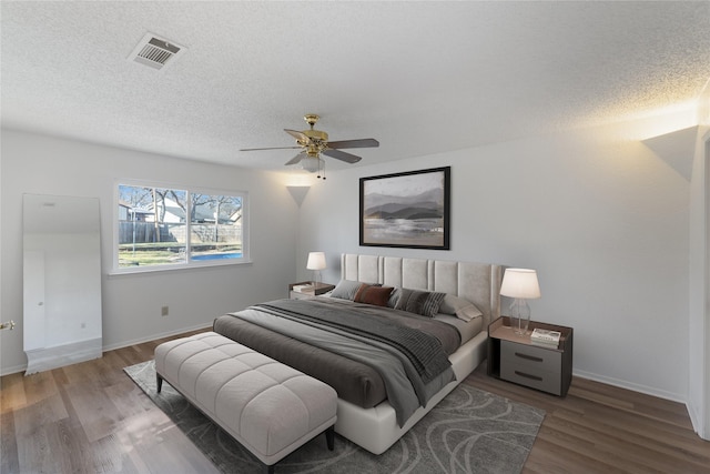 bedroom with hardwood / wood-style floors, a textured ceiling, and ceiling fan