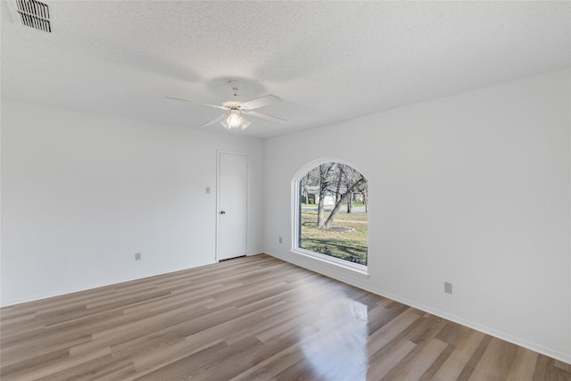 unfurnished room featuring ceiling fan, light hardwood / wood-style flooring, and a textured ceiling