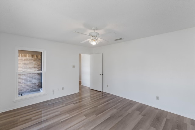 empty room with ceiling fan and light hardwood / wood-style flooring