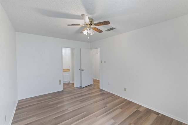 empty room with ceiling fan, a textured ceiling, and light hardwood / wood-style flooring