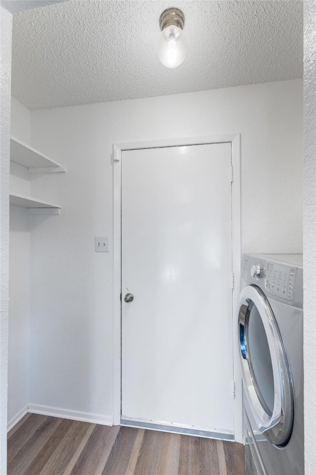 clothes washing area featuring a textured ceiling, washer / clothes dryer, and dark hardwood / wood-style floors