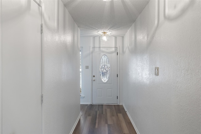 doorway to outside with a textured ceiling and dark hardwood / wood-style floors