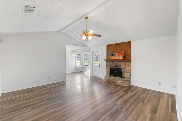 unfurnished living room with dark hardwood / wood-style flooring, a textured ceiling, ceiling fan, a fireplace, and vaulted ceiling with beams