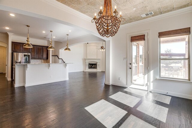 kitchen featuring pendant lighting, a fireplace, sink, stainless steel dishwasher, and a center island with sink