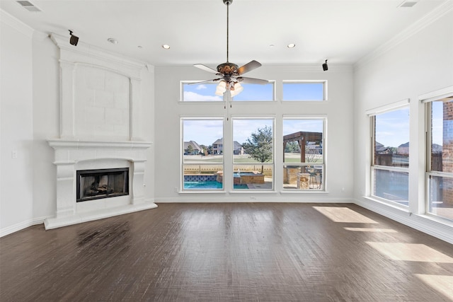 unfurnished living room with plenty of natural light, a large fireplace, and ornamental molding