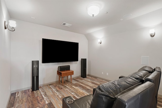 cinema with vaulted ceiling and light hardwood / wood-style floors