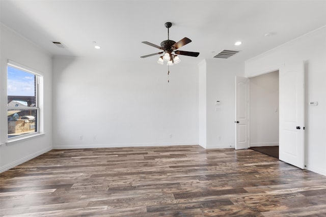 empty room with ceiling fan, dark hardwood / wood-style flooring, and ornamental molding