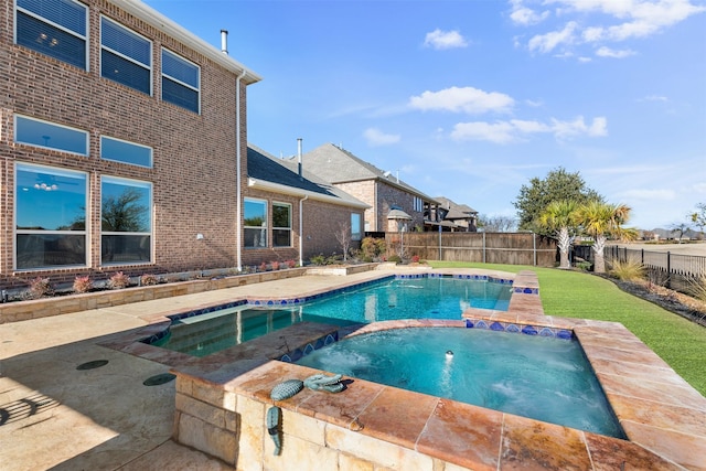 view of swimming pool with a lawn and an in ground hot tub