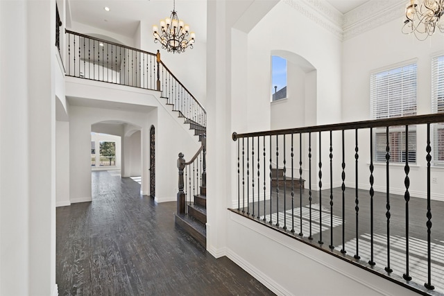 entrance foyer with dark hardwood / wood-style flooring, a high ceiling, and a chandelier