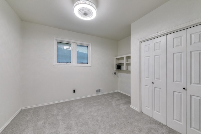 unfurnished bedroom featuring light carpet and a closet