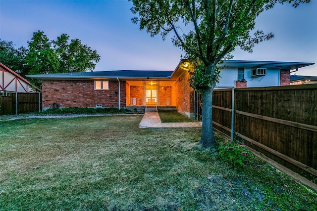 back house at dusk with a lawn