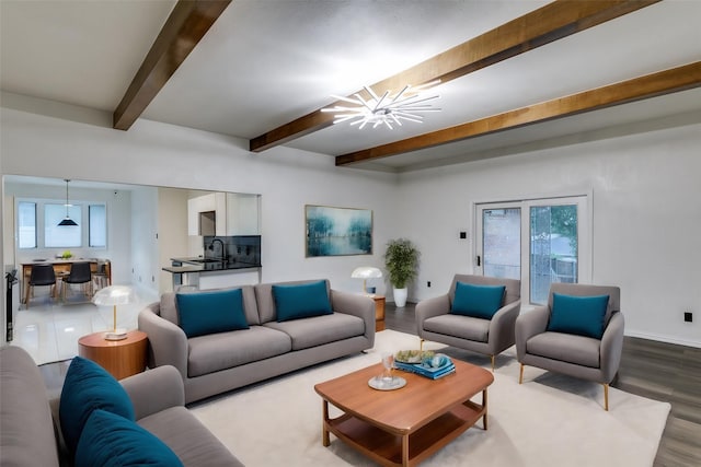 living room with hardwood / wood-style flooring, sink, beamed ceiling, and a notable chandelier