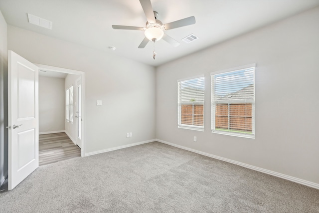 empty room featuring ceiling fan and light carpet