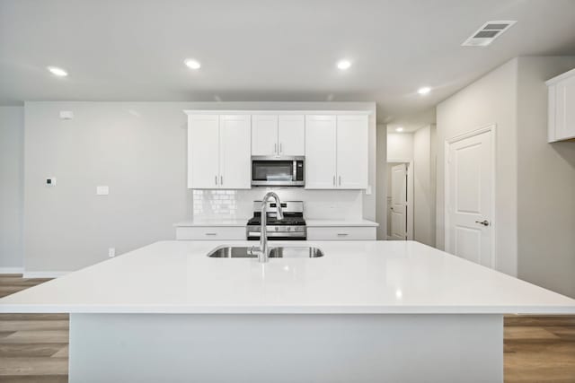 kitchen featuring light hardwood / wood-style floors, a spacious island, white cabinetry, and stainless steel appliances