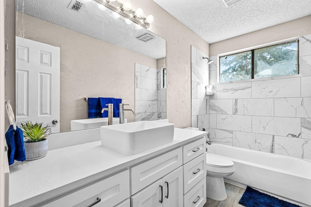 full bathroom with vanity, a textured ceiling, hardwood / wood-style floors, toilet, and tiled shower / bath