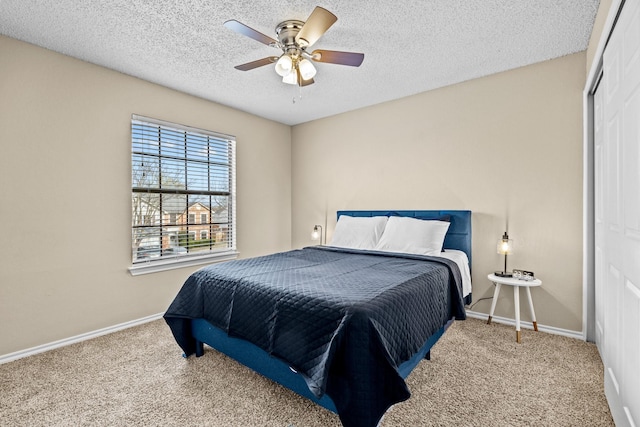 carpeted bedroom with ceiling fan and a textured ceiling