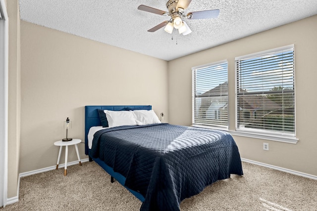 carpeted bedroom with a textured ceiling and ceiling fan