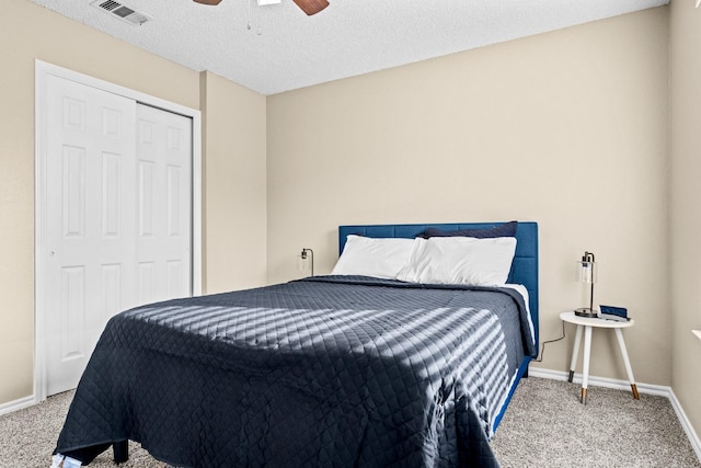 carpeted bedroom featuring a textured ceiling, a closet, and ceiling fan