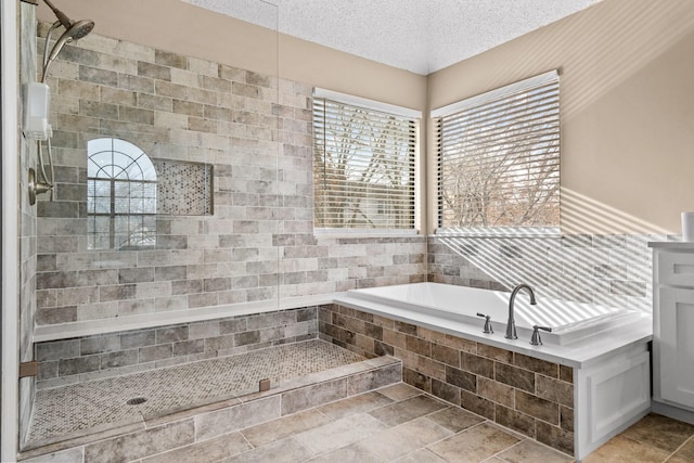 bathroom with separate shower and tub and a textured ceiling