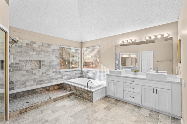 bathroom with plus walk in shower, a textured ceiling, and vanity