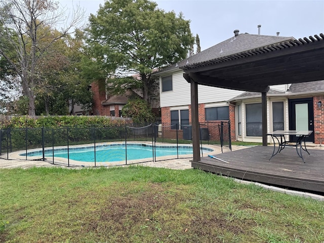 view of pool with a wooden deck and a lawn