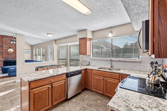 kitchen featuring light stone counters, sink, kitchen peninsula, and stainless steel appliances