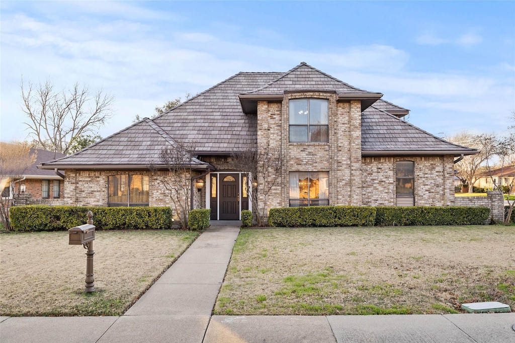 french provincial home with a front lawn