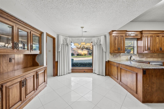 4247 Blackheath Rd, Dallas, TX 75227 - kitchen featuring light tile patterned flooring, sink, tasteful backsplash, decorative light fixtures, and dark stone countertops