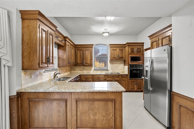4247 Blackheath Rd, Dallas, TX 75227 - kitchen with sink, tasteful backsplash, light stone countertops, black appliances, and kitchen peninsula