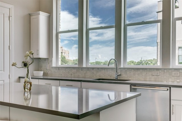 kitchen featuring dishwasher, decorative backsplash, white cabinetry, and sink