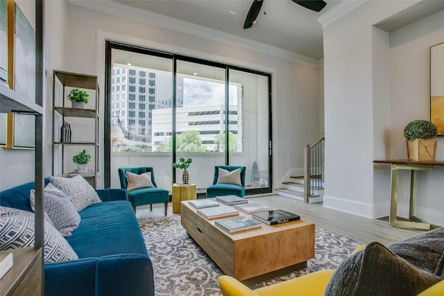 living room featuring ceiling fan, ornamental molding, and light hardwood / wood-style flooring