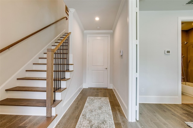 stairway featuring hardwood / wood-style flooring and ornamental molding