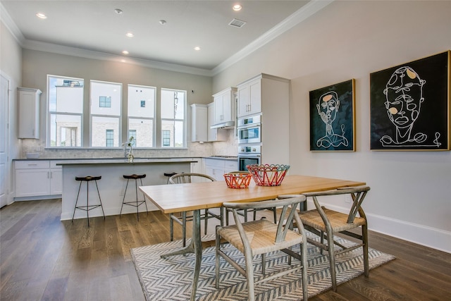 dining room featuring crown molding and dark hardwood / wood-style floors