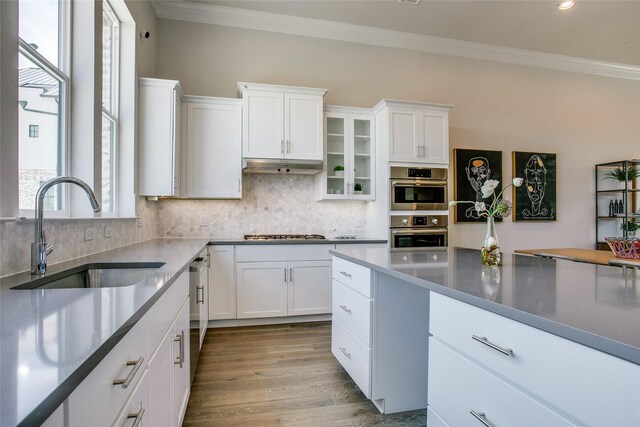 kitchen featuring white cabinetry, sink, stainless steel appliances, and light wood-type flooring