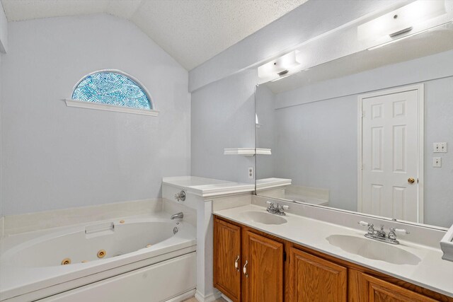 bathroom featuring vanity, a bath, a textured ceiling, and vaulted ceiling