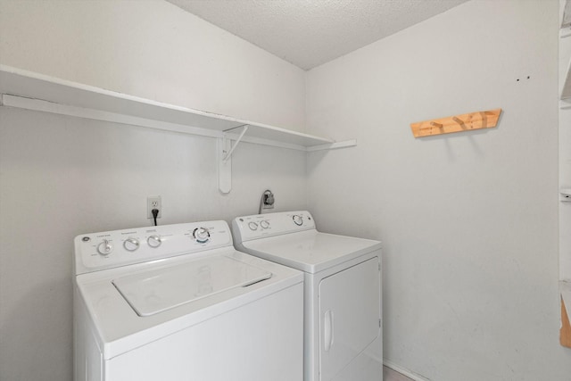 washroom featuring washing machine and dryer and a textured ceiling