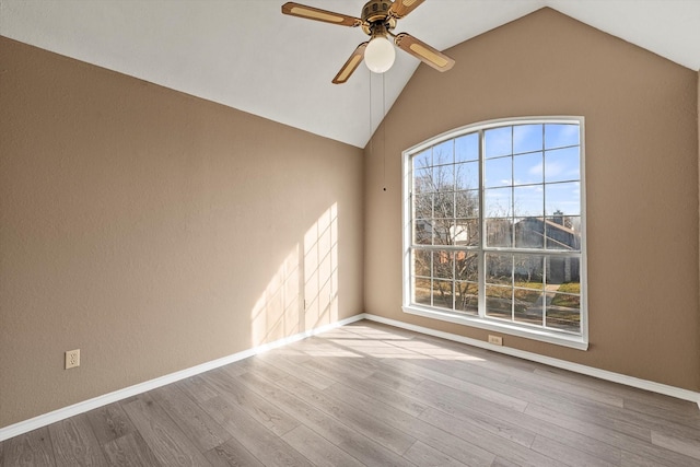 spare room with ceiling fan, light hardwood / wood-style floors, and vaulted ceiling