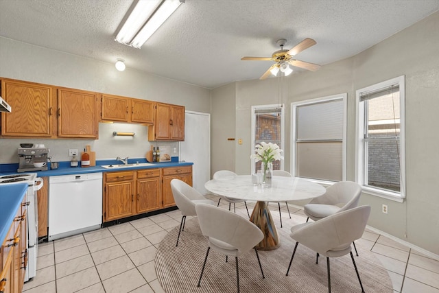 kitchen with stove, a textured ceiling, white dishwasher, ceiling fan, and light tile patterned floors