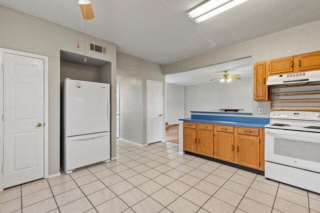 kitchen featuring a textured ceiling, white appliances, light tile patterned floors, and ceiling fan