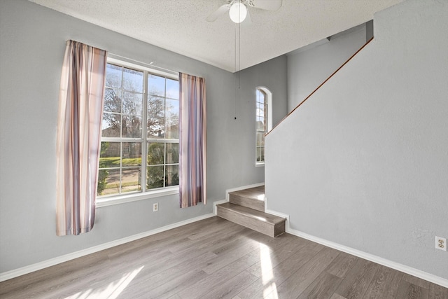 empty room featuring hardwood / wood-style floors, a textured ceiling, and ceiling fan