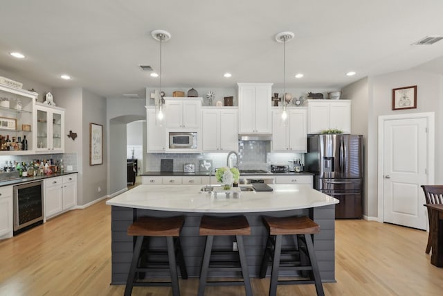 kitchen with stainless steel refrigerator with ice dispenser, built in microwave, decorative light fixtures, white cabinetry, and beverage cooler