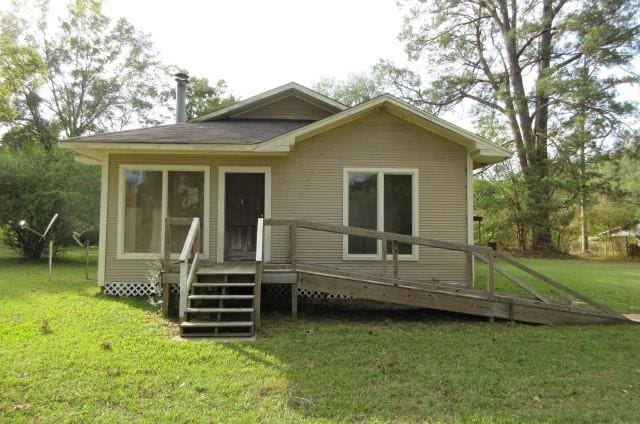 back of property with a wooden deck and a yard