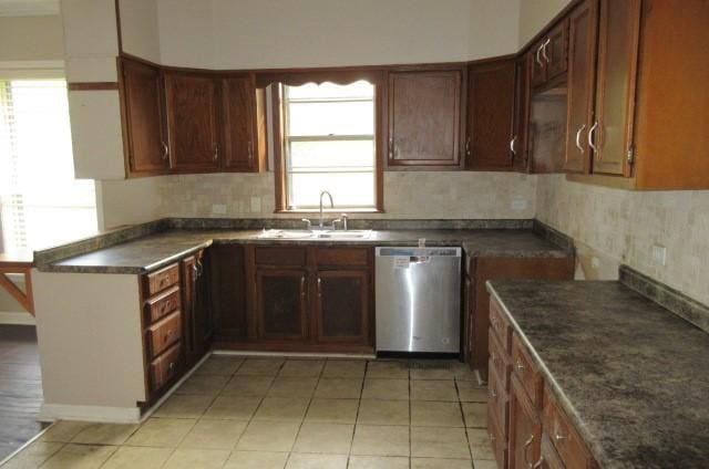 kitchen featuring sink, light tile patterned floors, stainless steel dishwasher, and decorative backsplash